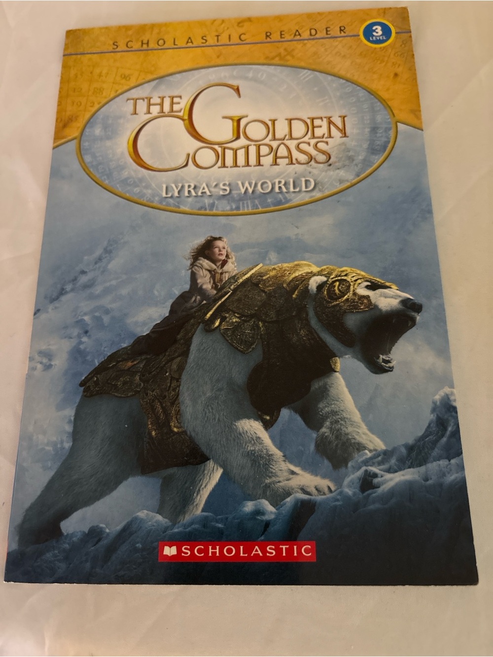 The Golden Compass Lyra's World Kids Paperback- Gold and White
